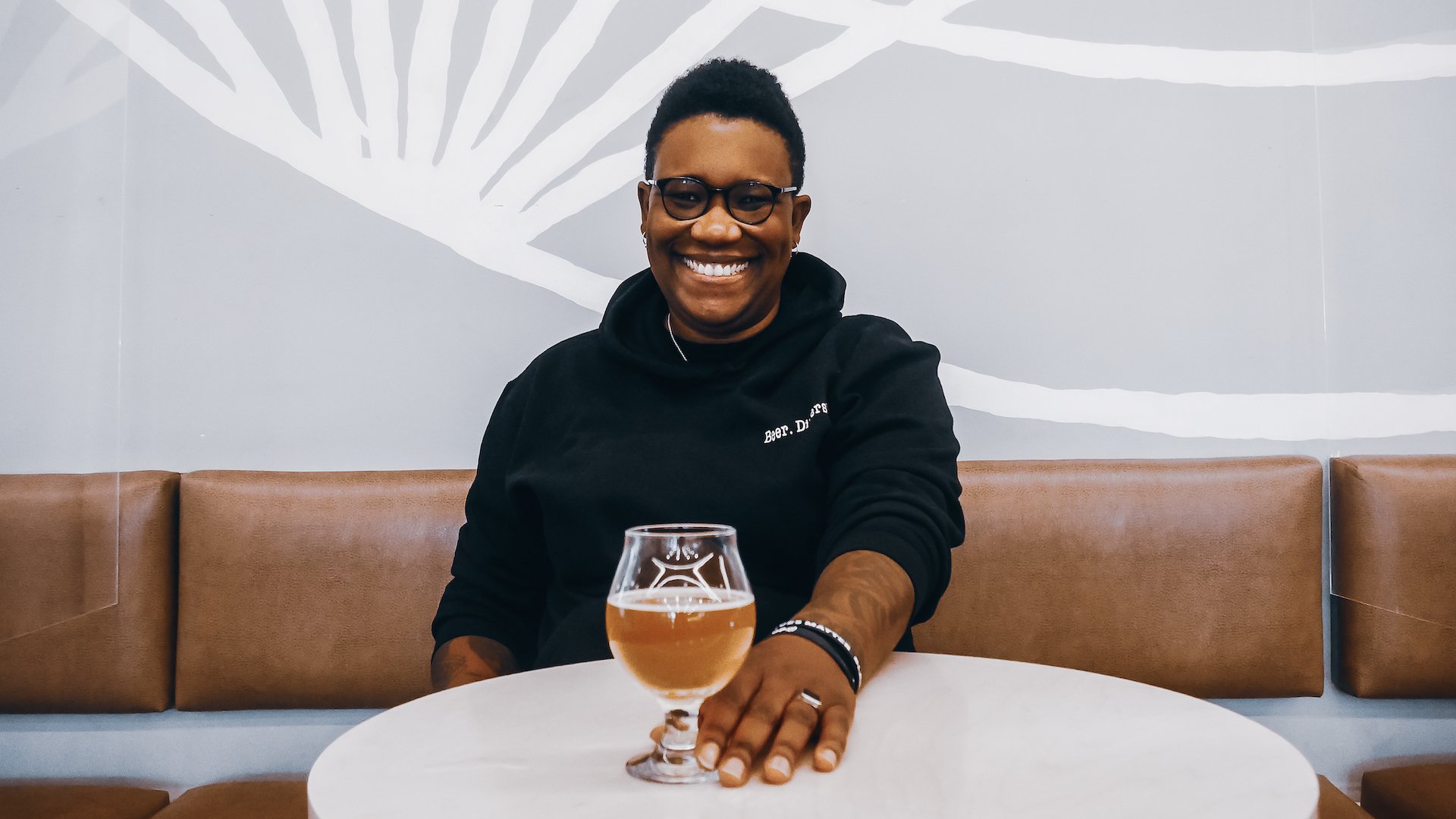 Ren Navarro sits a a table with a glass of beer.