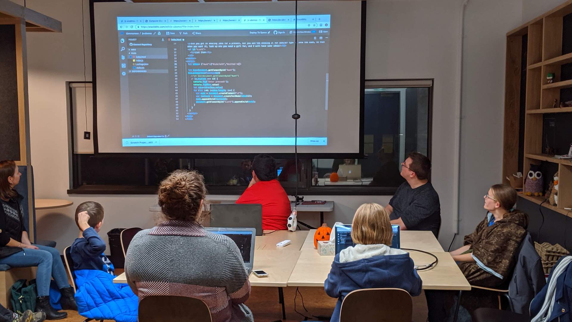 4H members sitting in front of a screen as a leader teaches them web programming basics