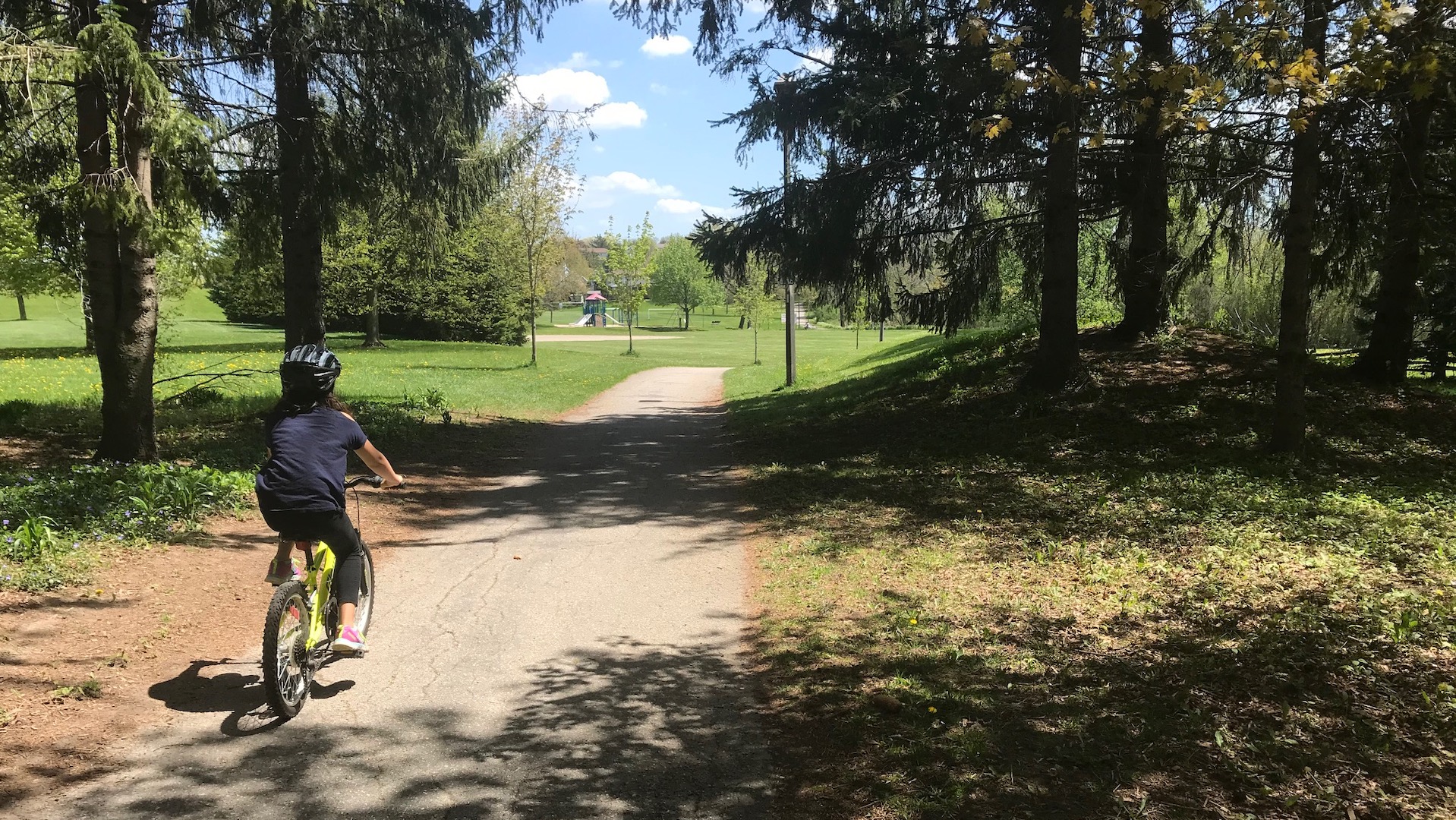 A child rides a bike on a multi use trail in Kitchener, Ontario.