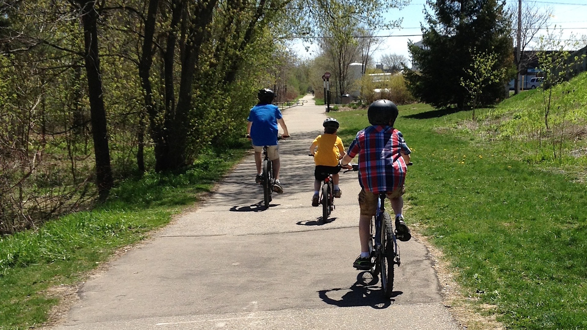 Three children ride bikes on a trail in Waterloo, Ontario.