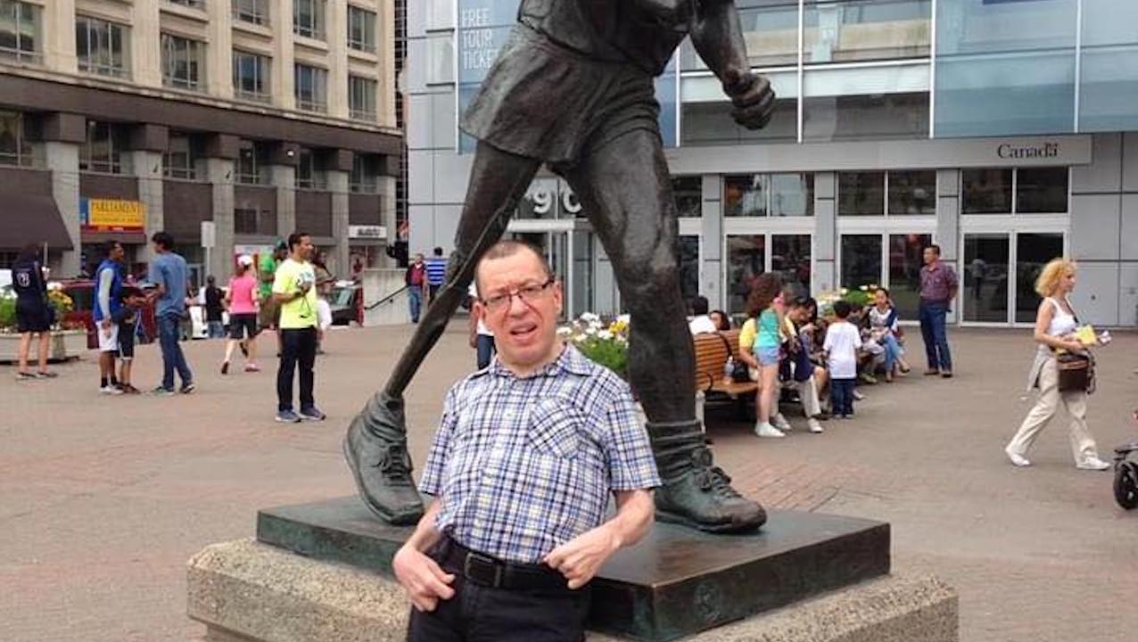 Dave Dame stands at the base of a statue of Terry Fox