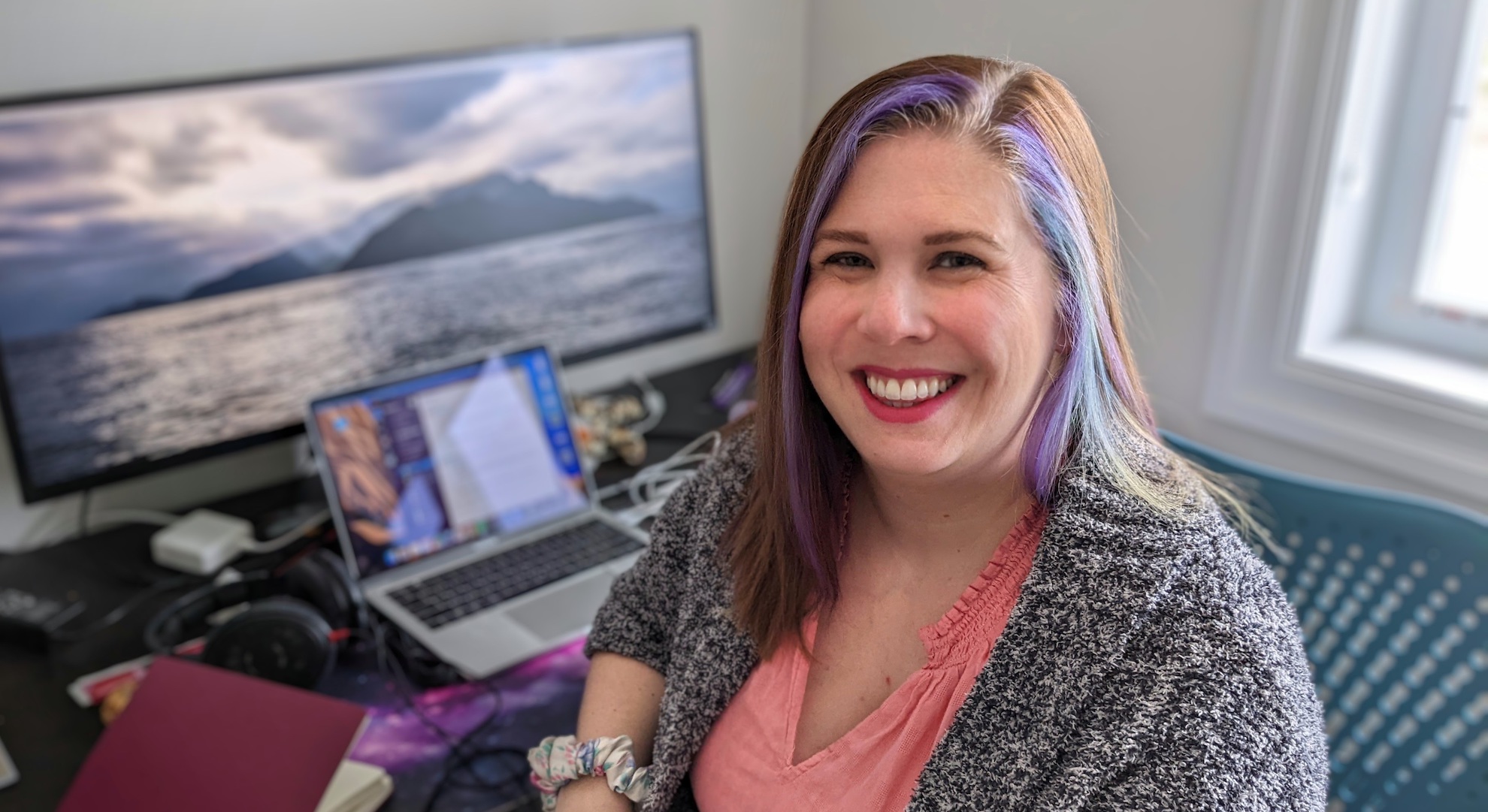 Zeitspace UX designer Megan Pollock sits at a desk with an open laptop.