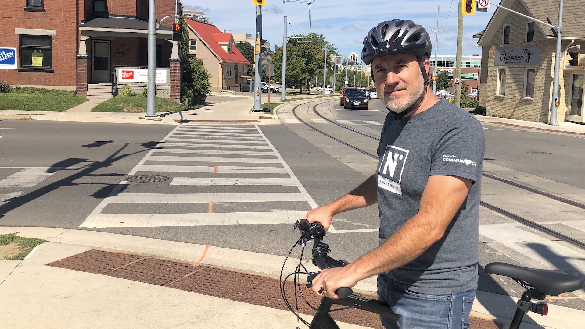 Tony Reinhart, with his bike near an intersection. A crosswalk leads to a multi-use trail that runs alongside the ION's tracks on Caroline St.