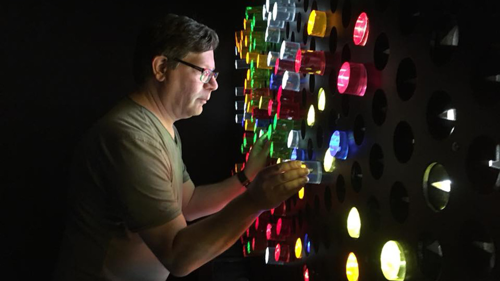UX researcher Steve Portigal looks at a colourful wall display.