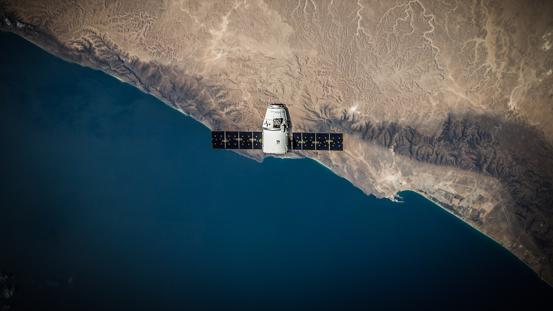 A Satellite above the earth featuring land an ocean.